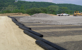The two-way stretched plastic geogrid is formed by extruding high molecular polymers to form a sheet, punching holes, and then stretching longitudinally and transversely.